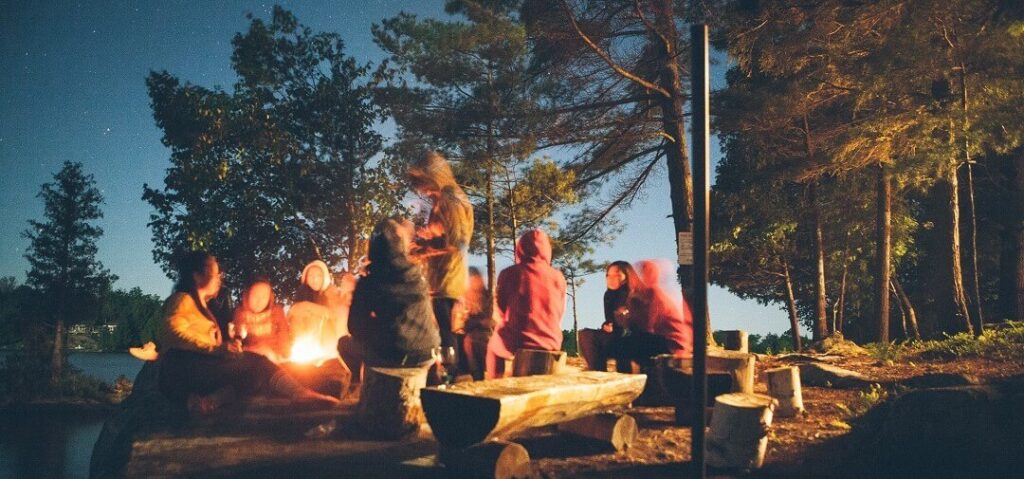 Hygge with others - gathering around campfire